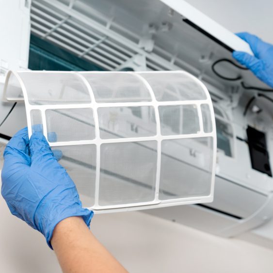 Hands replacing AC filter