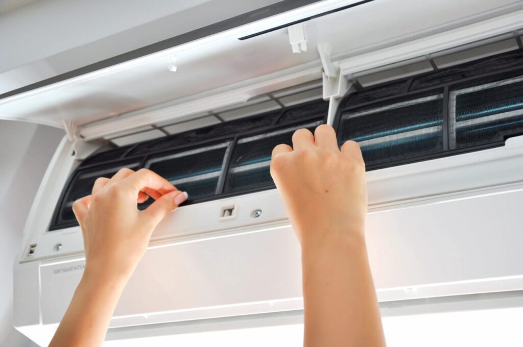 Person adjusting air conditioner filter
